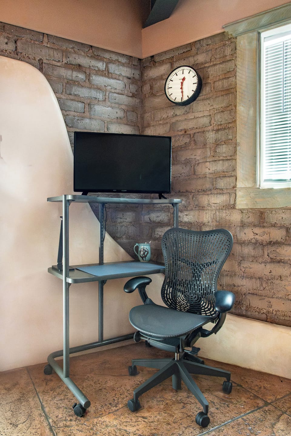 The first level has another Herman Miller office chair, desk, and 32' TV.
