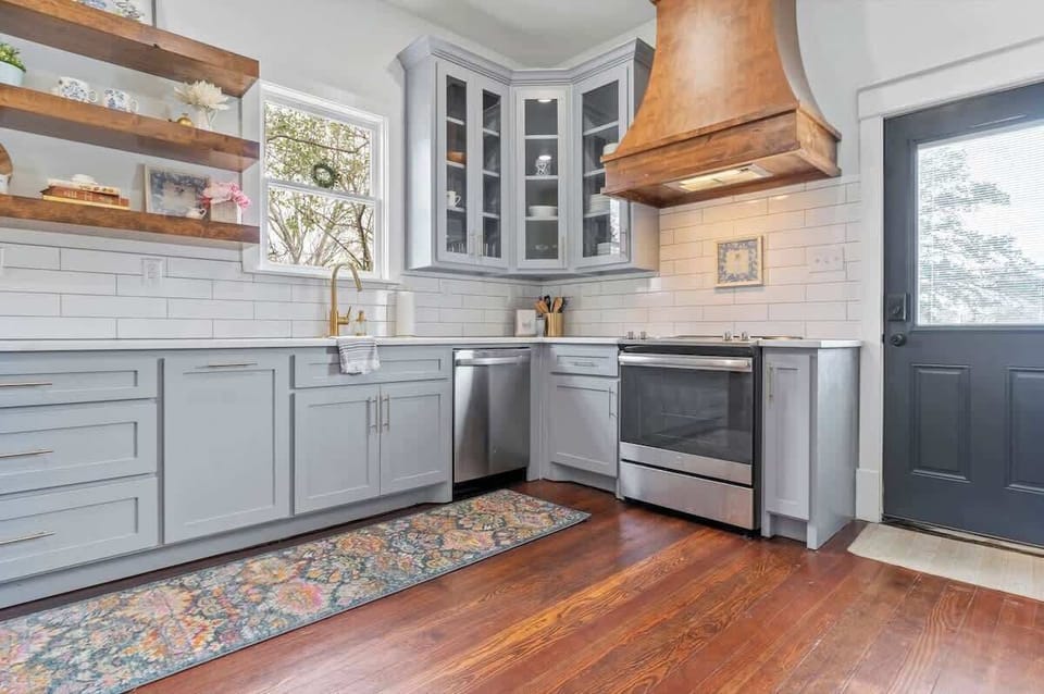 The kitchen is fully stocked and exits to the back porch and parking area.