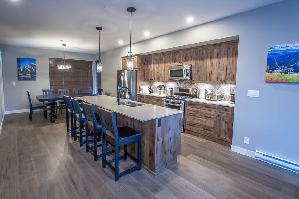 Large kitchen with four bar stools at island.