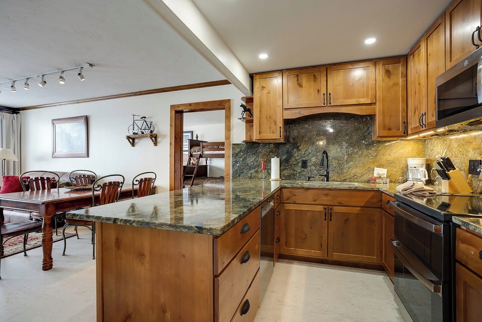Your gourmet kitchen features stunning granite counters, warm wood cabinetry, and a spacious island perfect for cooking memorable meals together.