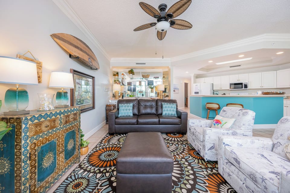 Enjoy a relaxing moment in this stylish family room with coastal accents, cozy seating, and vibrant colors