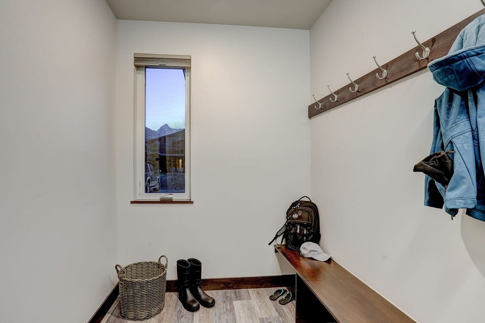 Mudroom with bench, hooks, washer and dryer.