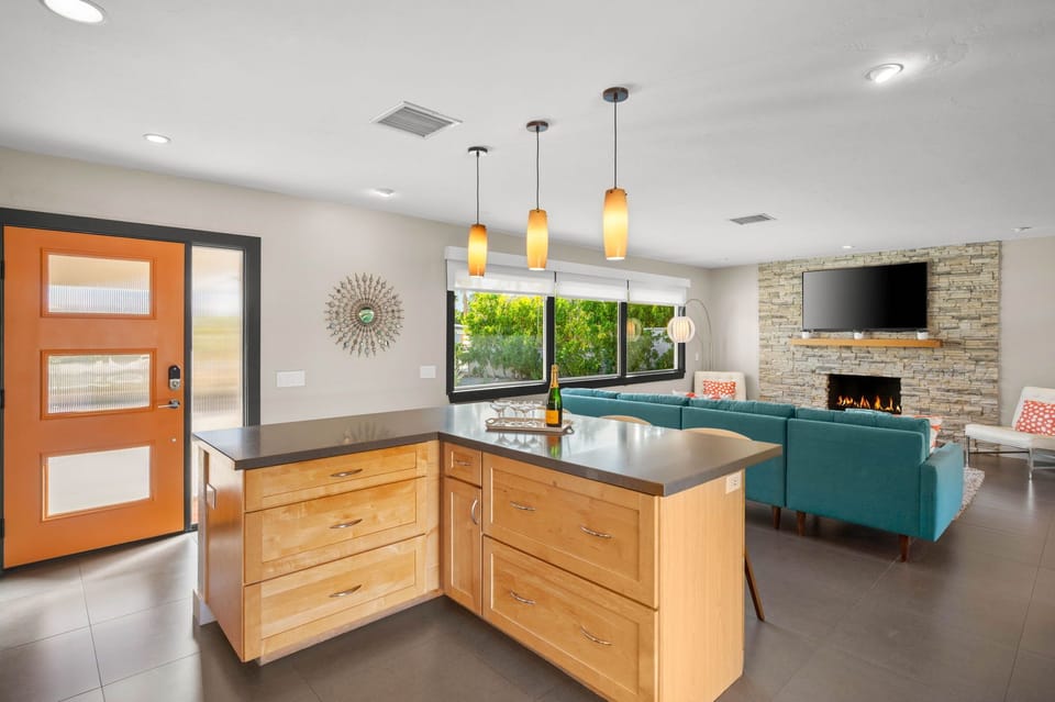 Your modern open-concept living space features a sleek kitchen island, cozy fireplace, and stylish seating perfect for gathering.