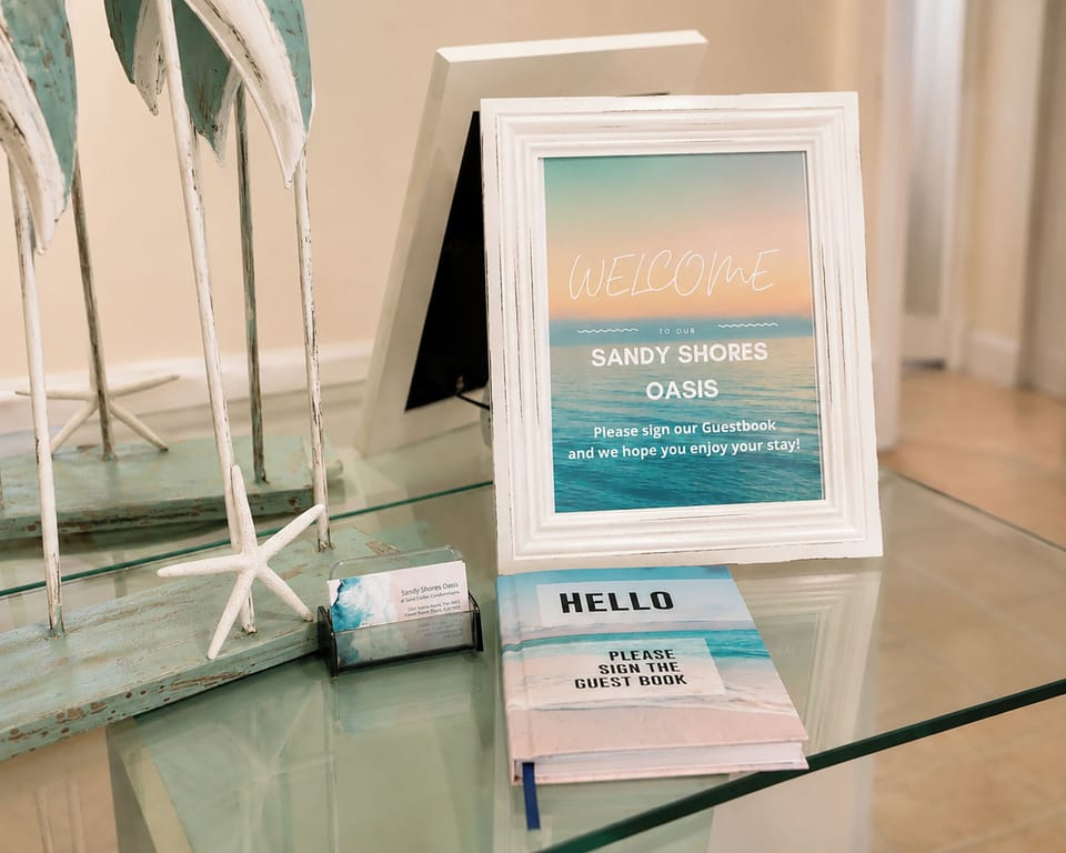 A thoughtfully styled coastal welcome station featuring a personalized guestbook