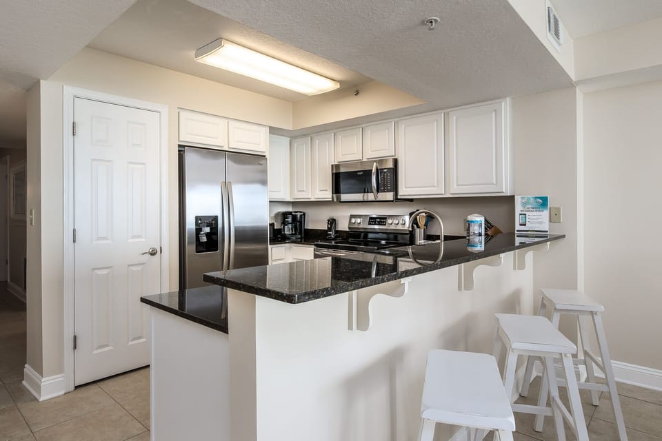 Kitchen View - Fully equipped kitchen with ample bar seating; perfect for entertaining or additional seating for the family