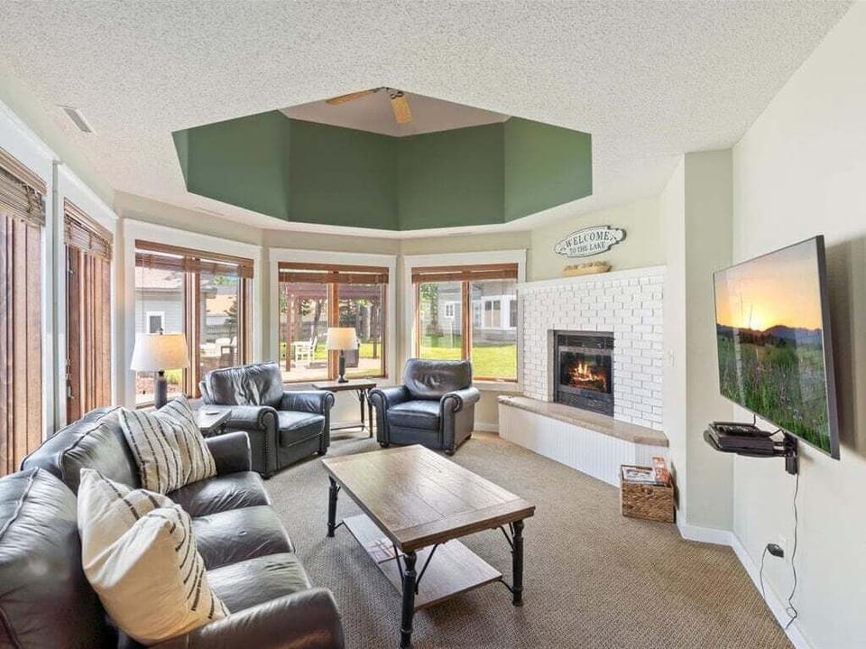 Cozy living room with plush seating, a warm fireplace, and large windows - perfect place to unwind after a day on the water | Gull Lake Rentals | Lakeside Rentals | Gull Lake, Minnesota