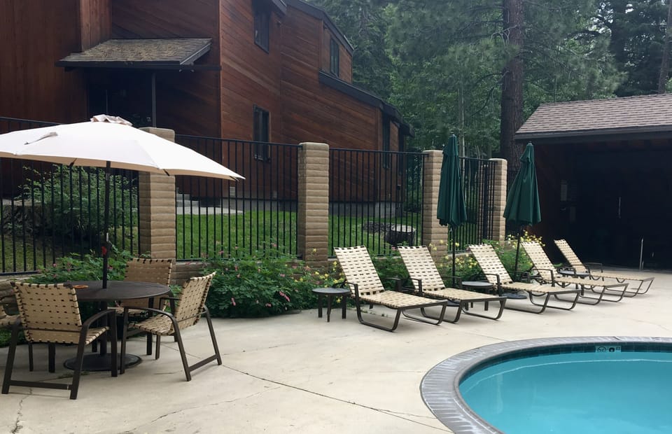 In summer, patio tables and chaise lounges surround the pool.