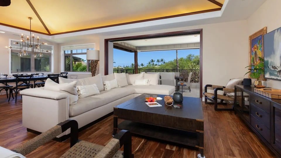 Open concept living area with large sectional and woven grasscloth ceiling