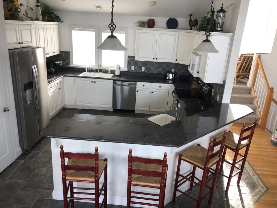 Kitchen, with bar showing seating for 4