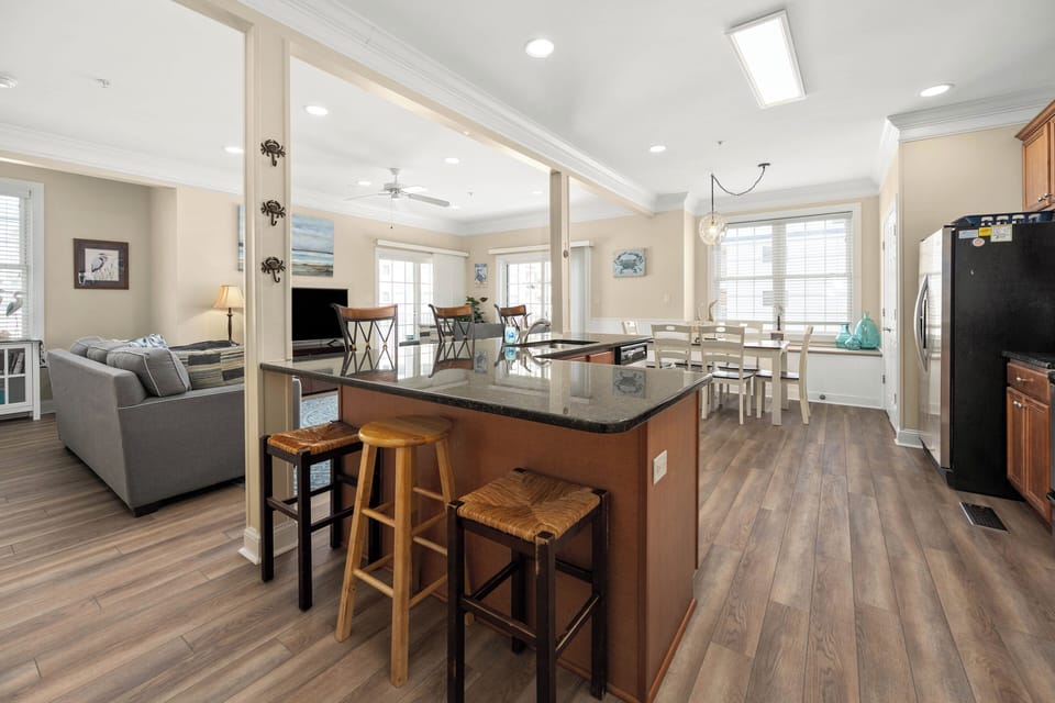 Bright open-concept kitchen, dining, and living space with island seating