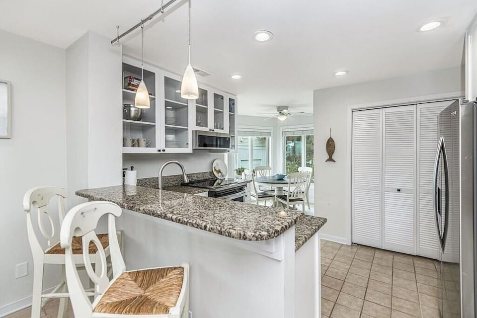 Kitchen with stainless steel appliances and prep island with seating. Tidewater 101I, Isle of Palms, SC | IOP Escapes