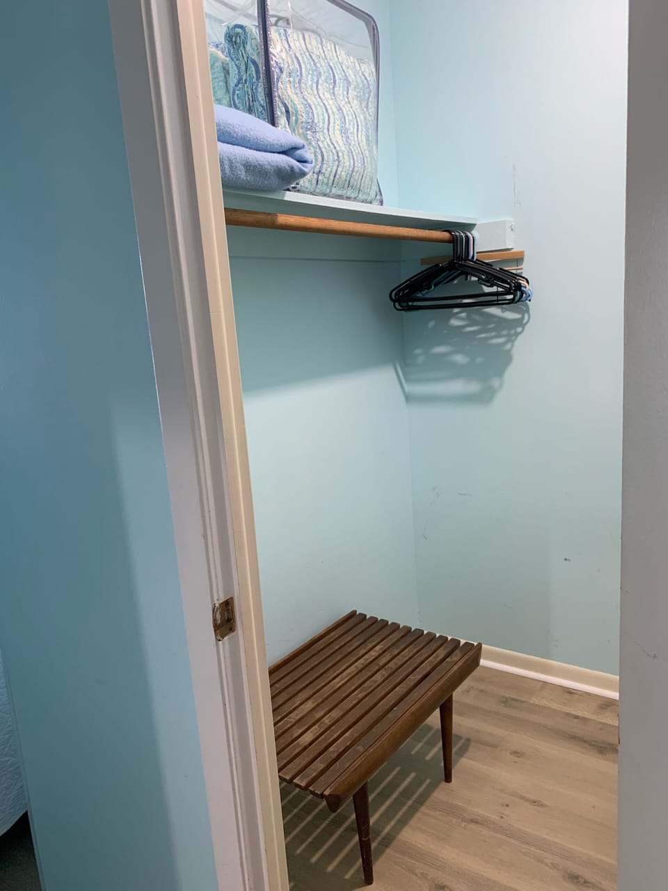 Walk in closet with luggage shelf, extra blankets and pillows. 