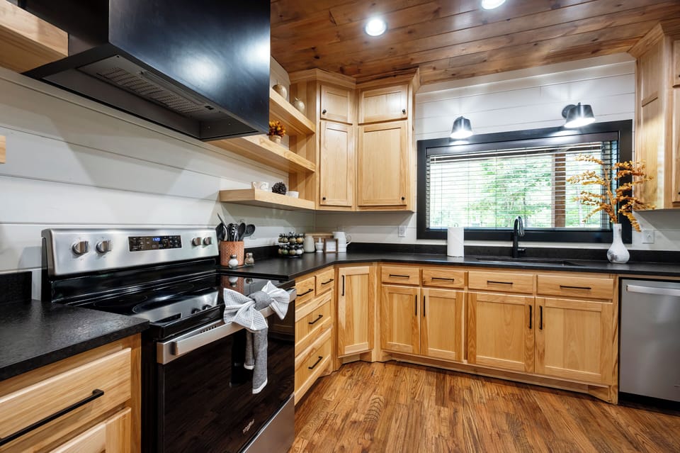 Your fully-equipped kitchen features warm wood cabinetry, sleek black countertops, and modern appliances—everything you need to whip up a delicious meal during your stay.