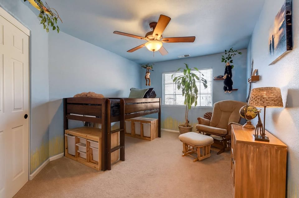 Warm, nature-inspired kids’ room with loft bed and cozy seating.