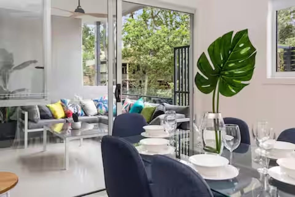 Covered patio with leafy outlook, dining area and 8-burner BBQ.