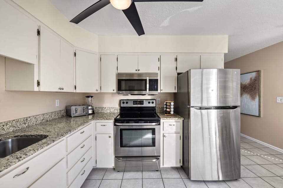 Sleek stainless appliances anchor the kitchen with a modern, polished look.