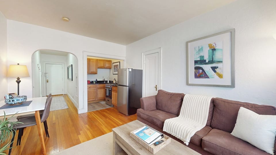 Open living area with warm wood floors and cozy seating.