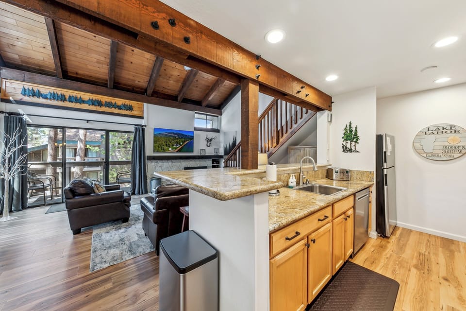 Your open-concept space blends rustic charm with modern comfort, featuring exposed beams overhead and a fully equipped kitchen ready for your culinary adventures.