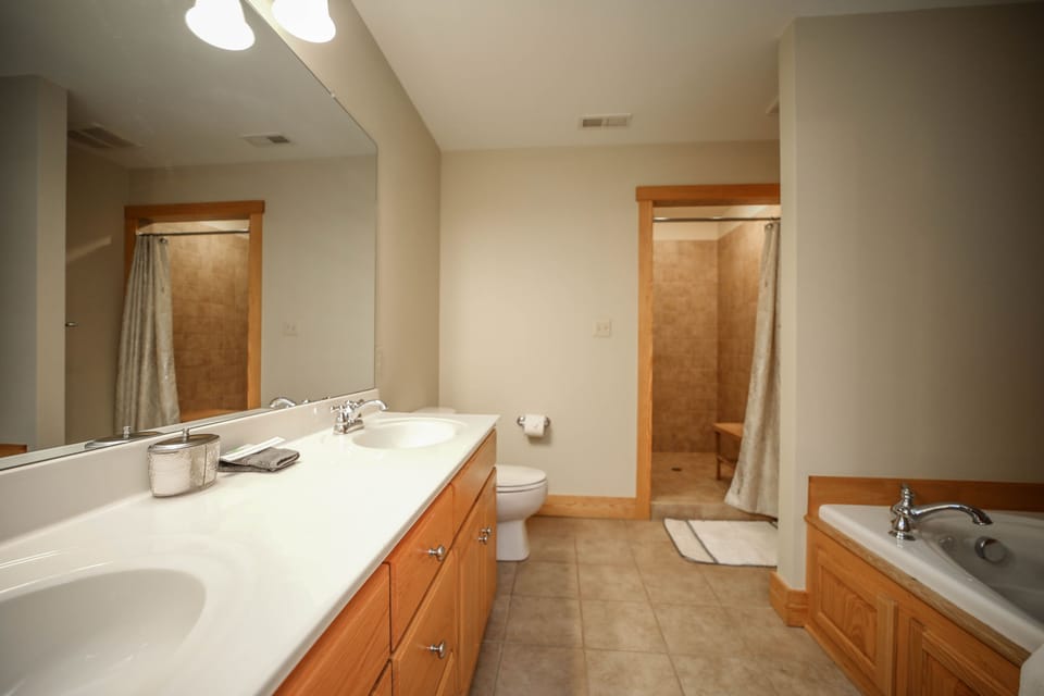 Primary ensuite bathroom with jetted tub and walk in shower