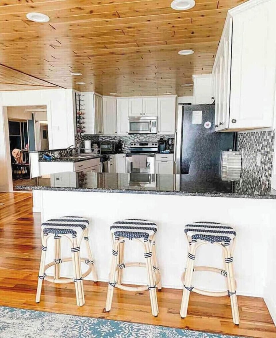 Fully stocked kitchen with breakfast bar and dining table that seats 8