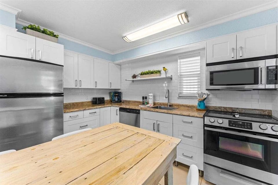 Fully equipped kitchen with granite counters, stainless steel appliances, dishwasher, and a cozy dining nook — everything you need for a home-cooked meal.