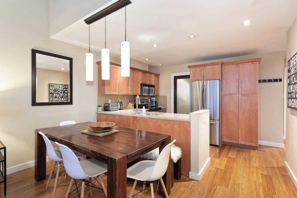 - Dine together at a rustic wooden table for six  
- Open-concept kitchen ideal for family gatherings  
- Pendant lights add warmth to your Whistler meals  
