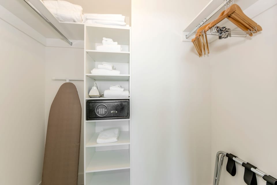 Walk-in closet: with hangers, safe box and ironing board.