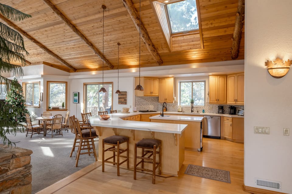 Kitchen, Island with sink, Reg coffee maker, Fire extinguisher, dishwasher, and wrap-around kitchen counter with stools for extra seating.