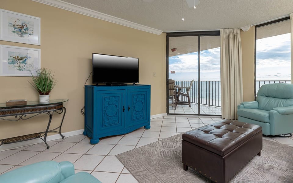 Relax in the inviting living area, featuring a TV, sofa with queen sleeper, and views of the beach balcony