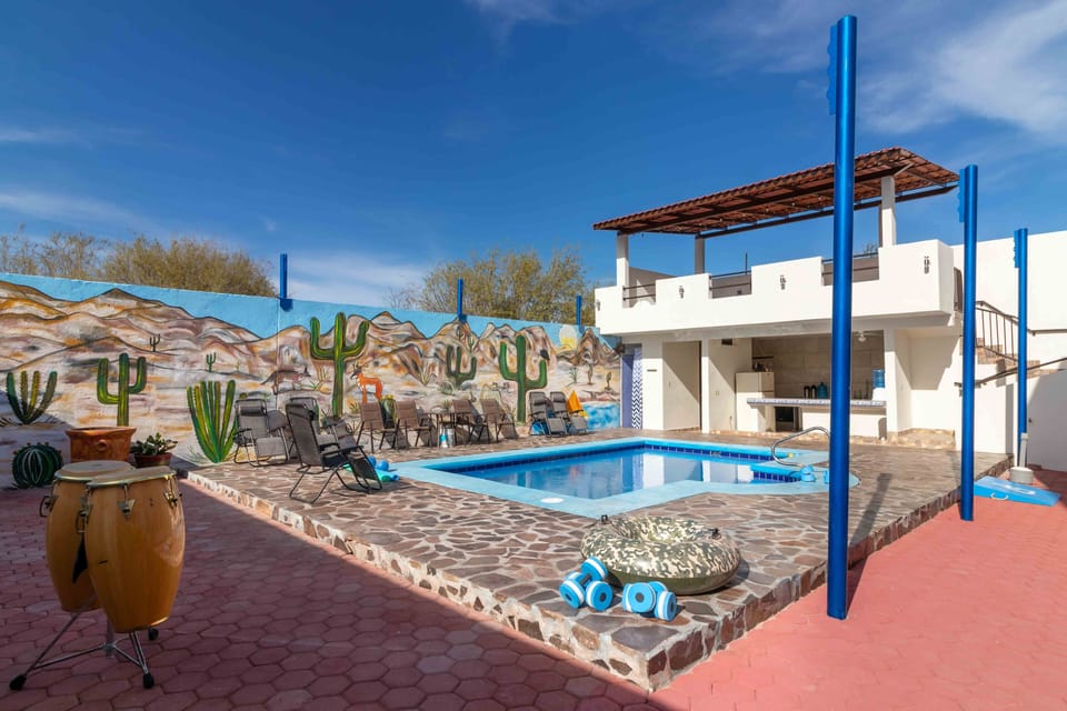 Gym equipment is located on the terrace above outdoor kitchen, overlooking pool.