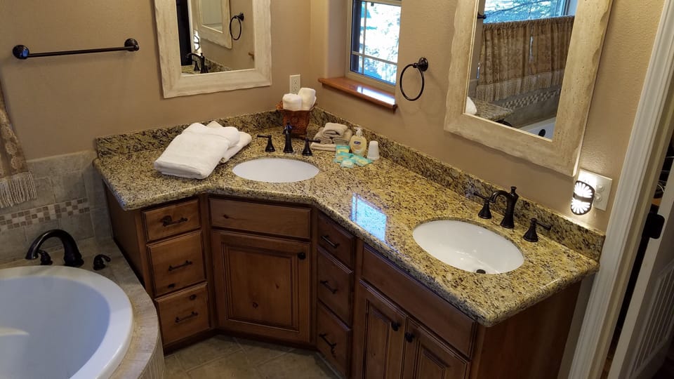 Master bathroom ensuite with custom cabinets, granite counter, and double sinks.