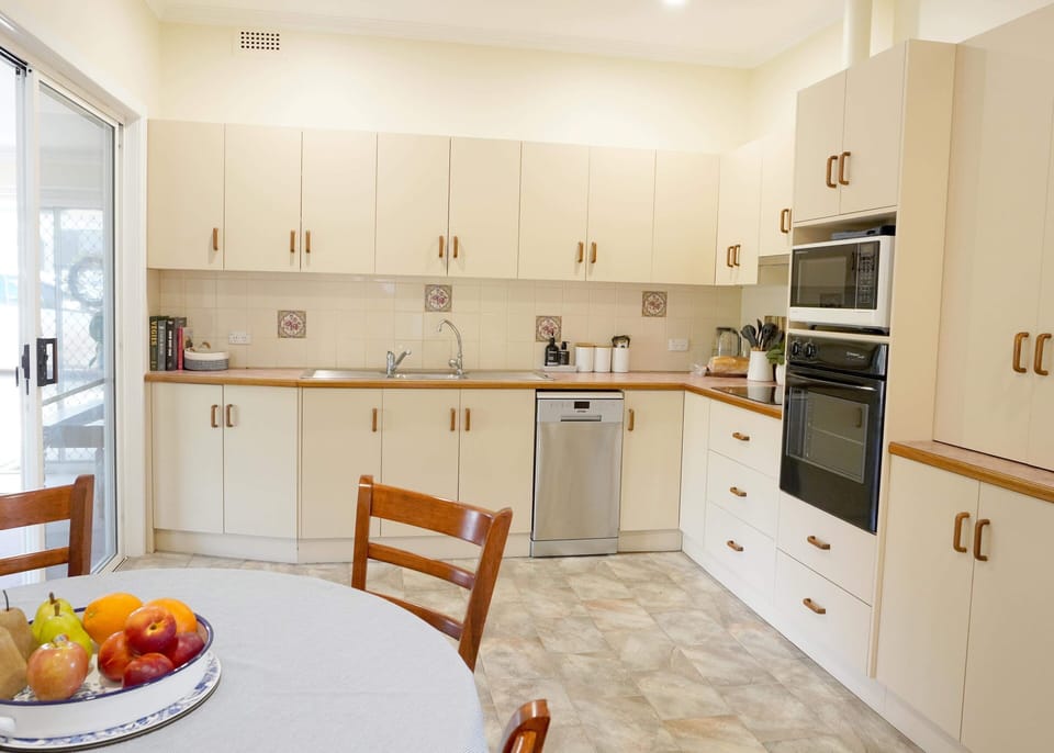 Kitchen featuring dishwasher, oven, stove, fridge & basic utensils & cookware.