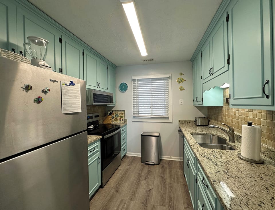 Roomy galley kitchen with stainless steel appliances.