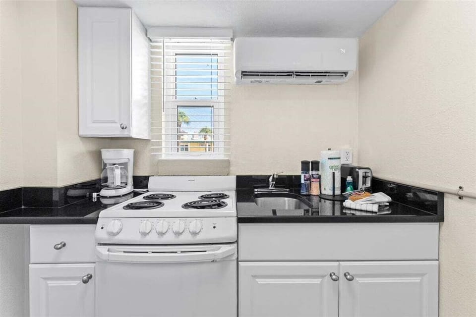 Compact kitchenette with a stove, fridge, microwave, coffee maker, and dedicated mini-split AC — everything you need for easy meals during your stay.