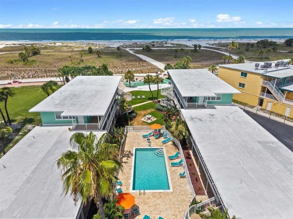 Tropic Terrace sits right on the beach, with a lush pool courtyard tucked between buildings and the Gulf just steps away. Sun, sand, and resort charm all in one place.
