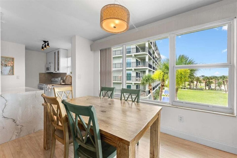 Sunny dining area with seating for six and beautiful Gulf and grounds views — a bright, airy spot to enjoy meals together.