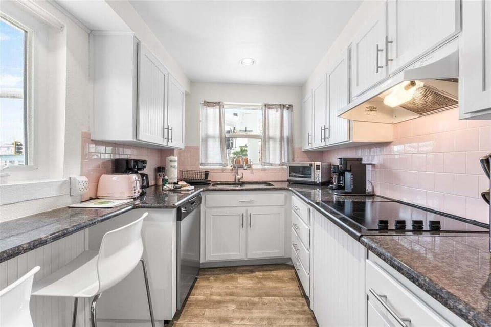 Fully equipped kitchen with stainless steel appliances, dark granite counters, and everything you need — dishwasher, stove, microwave, toaster oven, toaster, coffee maker, blender, and crock pot.