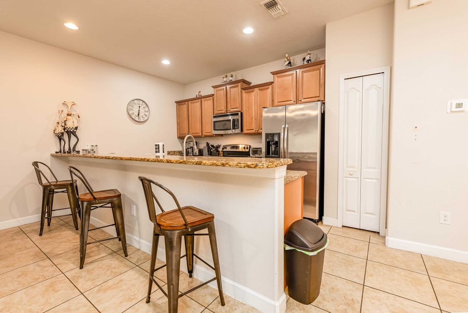 Open-concept space with a dining table for 6 and a breakfast bar with stools.