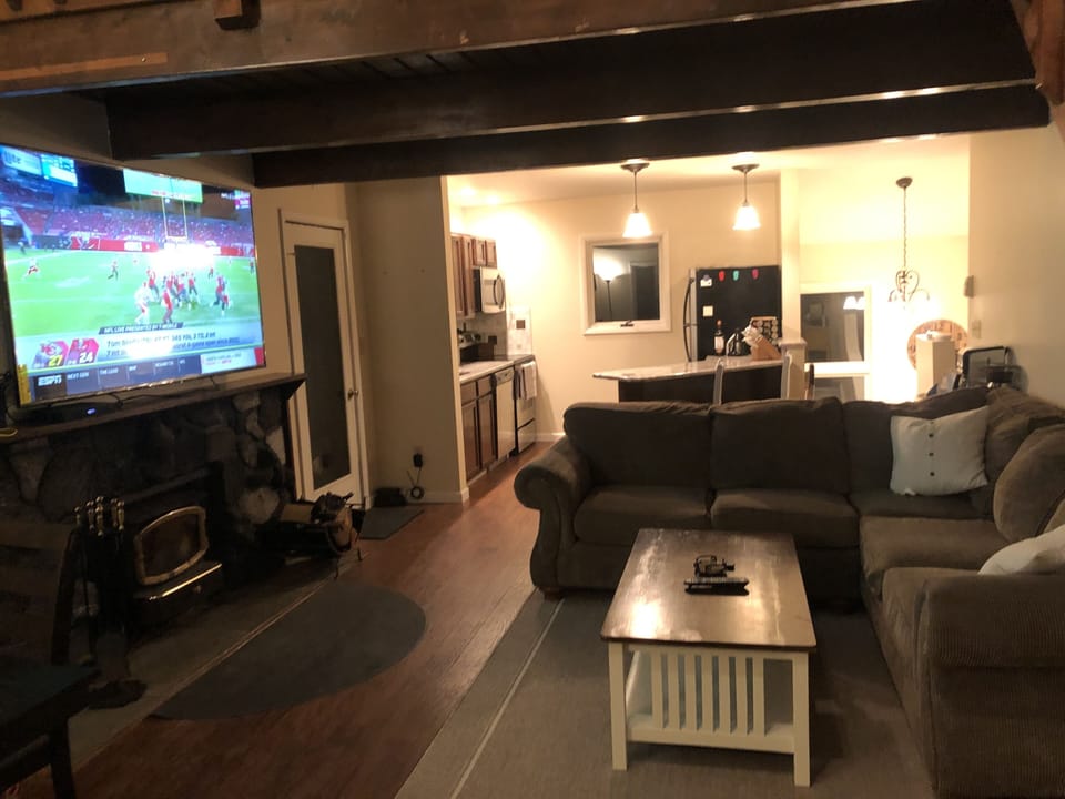 Living room into kitchen with 70” smart tv and fireplace 