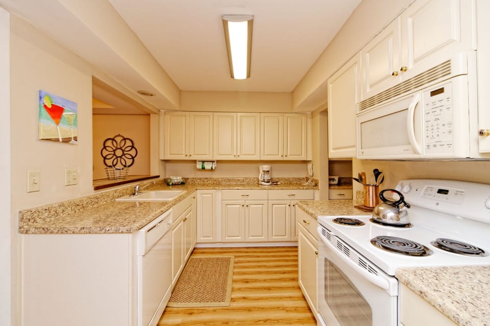 White cabinetry, granite countertops, and ample workspace