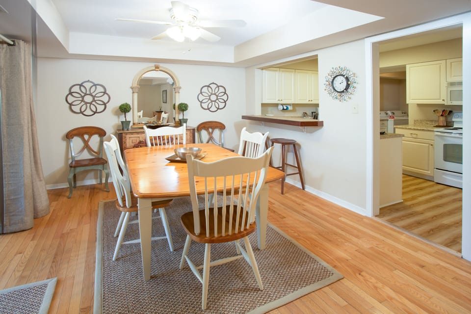 Dining area features warm hardwood floors, a skylight and ceiling fan