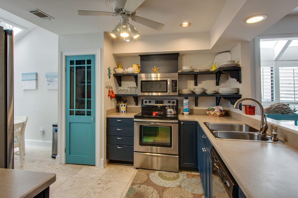 The open layout features a generous breakfast bar with a double sink, stainless steel appliances, and ample counter space for meal prep.