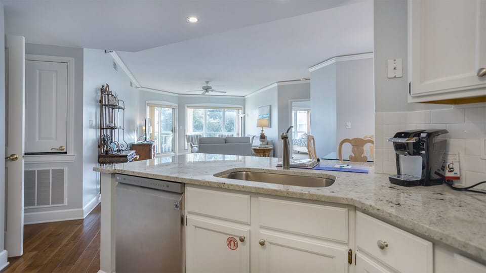 The spacious layout flows seamlessly into the dining and living areas—perfect for preparing meals, gathering with family, or entertaining after a day at the beach.