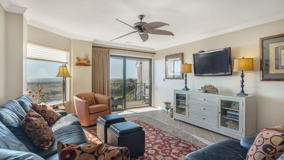 This inviting living area is designed for comfort and connection, with ample seating, warm coastal tones, and thoughtful furnishings throughout.