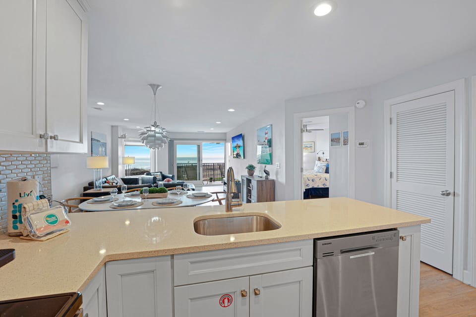 The spacious kitchen overlooks the dining and living areas, creating the perfect space for entertaining or relaxing after a day at the beach.