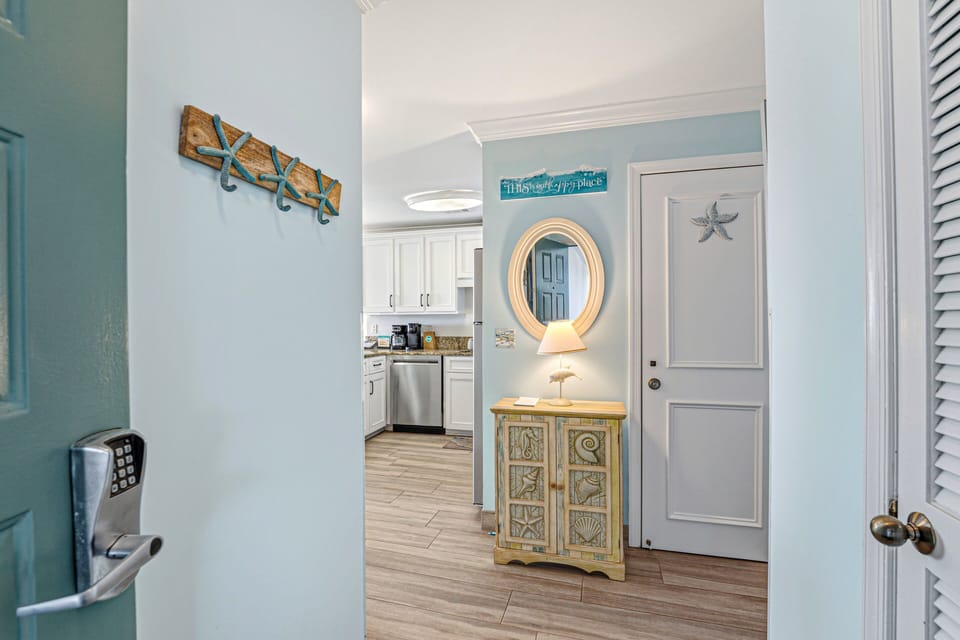 A welcoming entry sets the tone as you step inside, featuring a wood floor foyer with soft coastal colors and classic finishes.