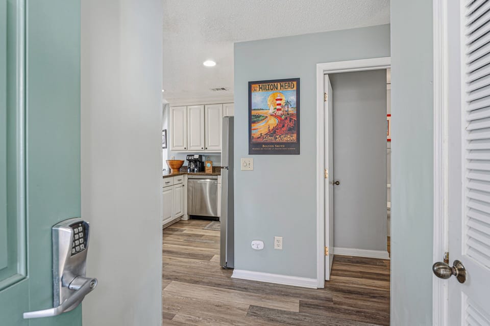 A welcoming entry sets the tone as you step inside, featuring a wood floor foyer with soft coastal colors and classic finishes.
