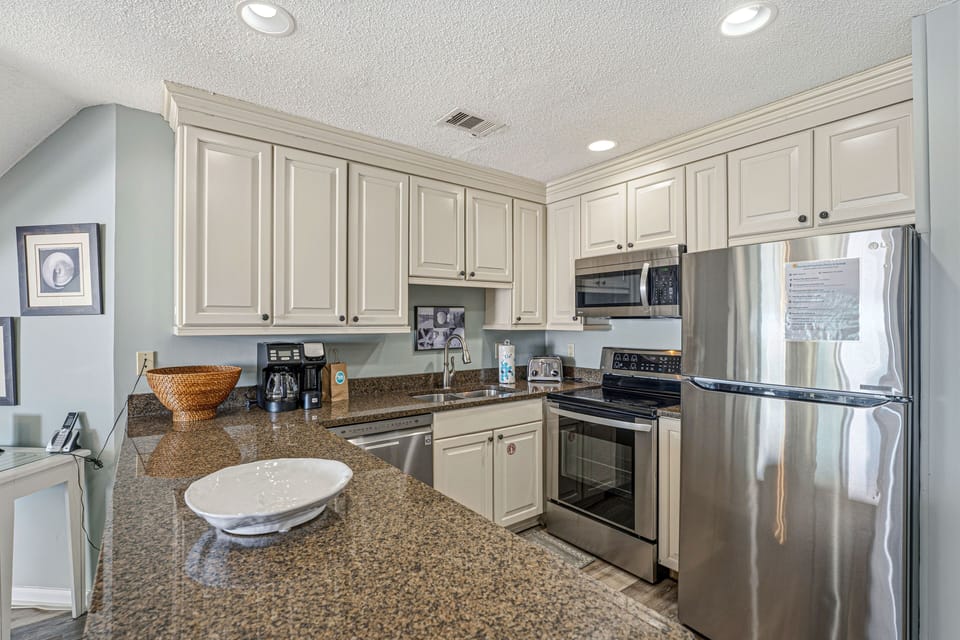 This well-appointed kitchen features off-white cabinetry, stainless steel appliances, and a spacious peninsula.