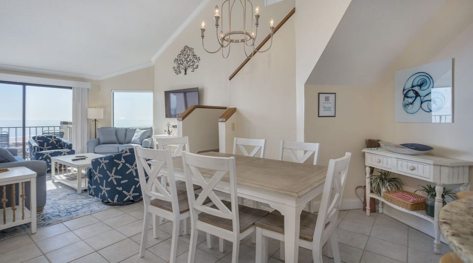 The dining area provides comfortable seating for family meals and game nights, featuring a classic wood table and matching chairs.