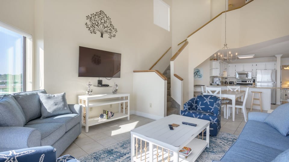 The layout flows naturally toward the kitchen and dining area, while the staircase adds character without crowding the space.